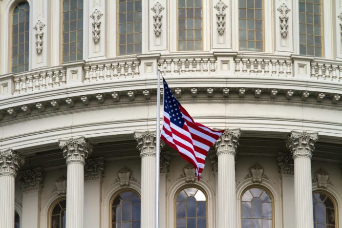 Close-up of the American flag waving outside the United States Capitol in Washington, DC.